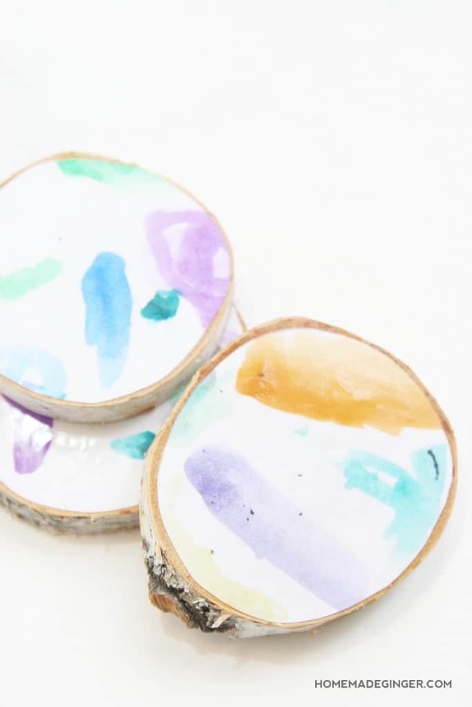 Turn kids art into adorable wood slice coasters! These DIY coasters couldn't be easier to make and look adorable displayed on the coffee table!